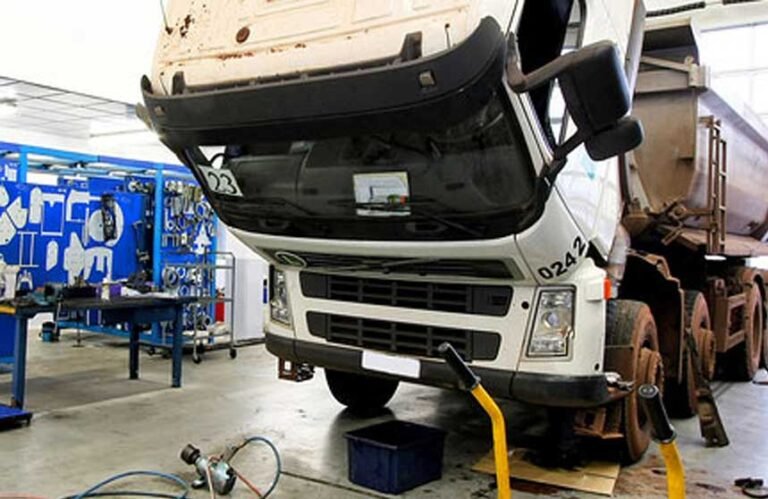 White truck with cab tilted for engine repair