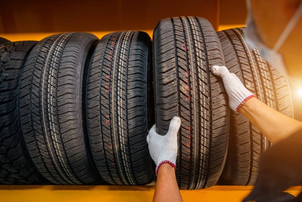 Person reaching for tire on yellow shelf