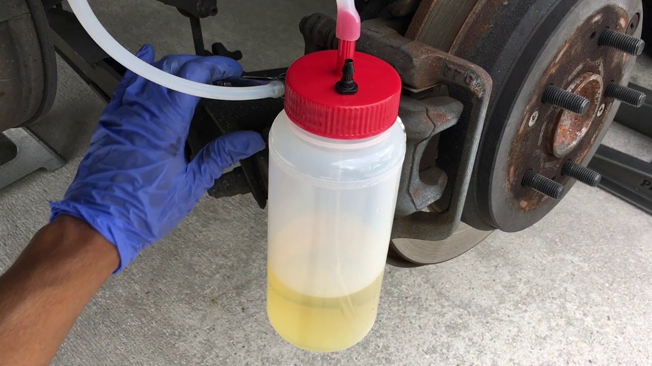 brake-fluid-change-closeup-scene Brake fluid change with tube and bottle